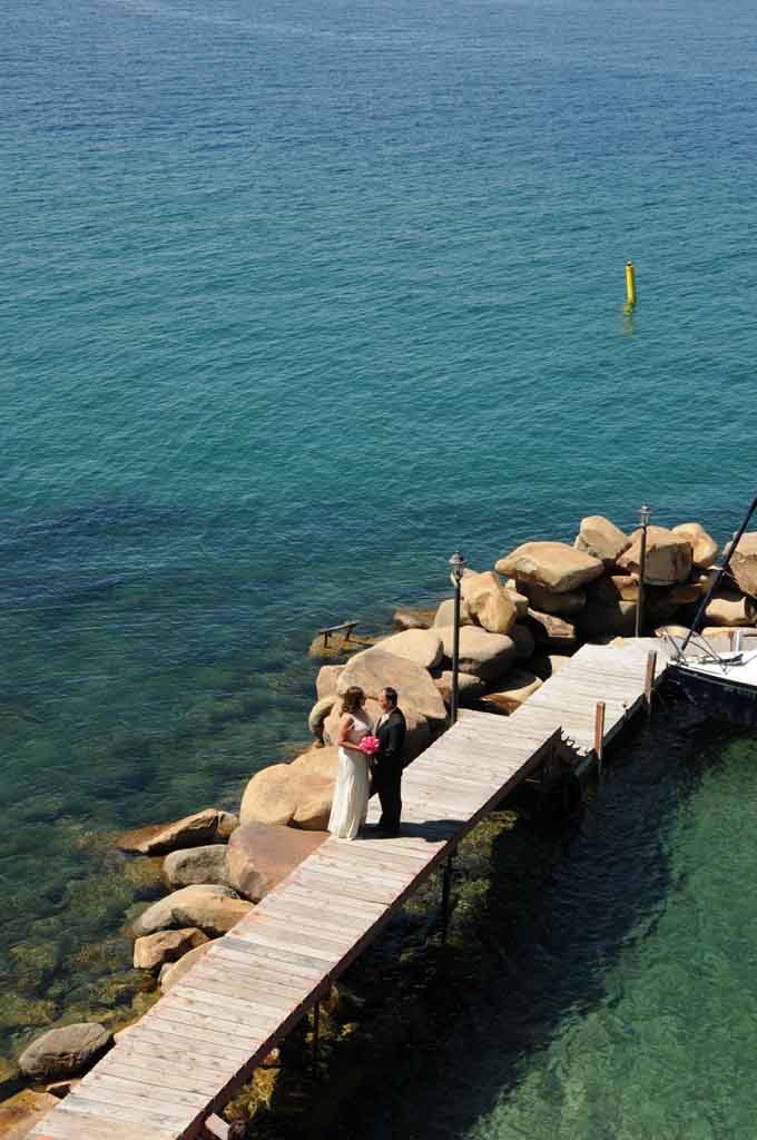 Bride and Groom holding hands on pier