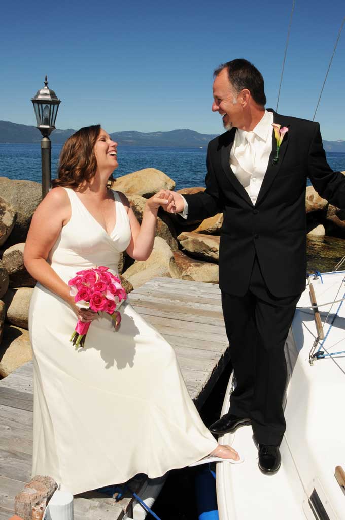 Groom helps bride onto the boat