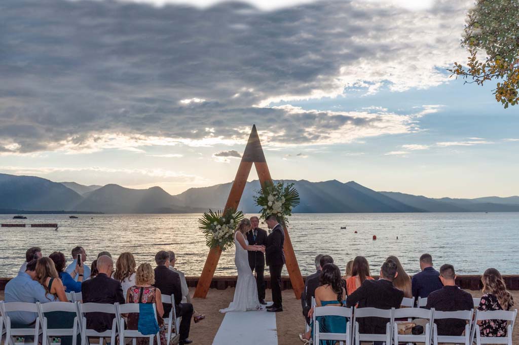 Bride and groom exchanging vows in front of the arch.
