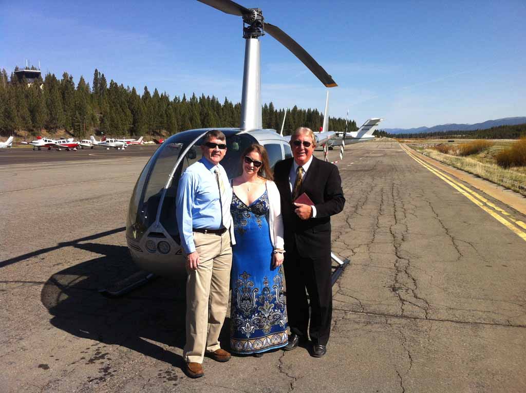 Minister and the newly wedded pose together in front of the parked helicopter