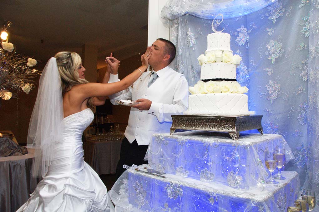 The bride smashes cake into the her groom's mouth