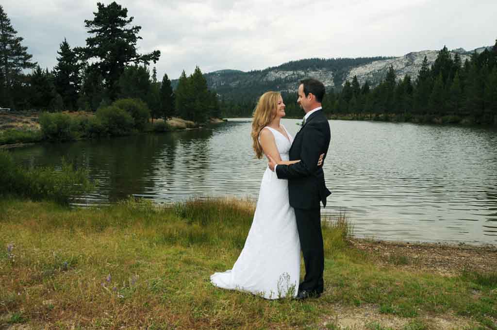 Bride and groom embracing near Lake Baron at Tahoe Paradise Park