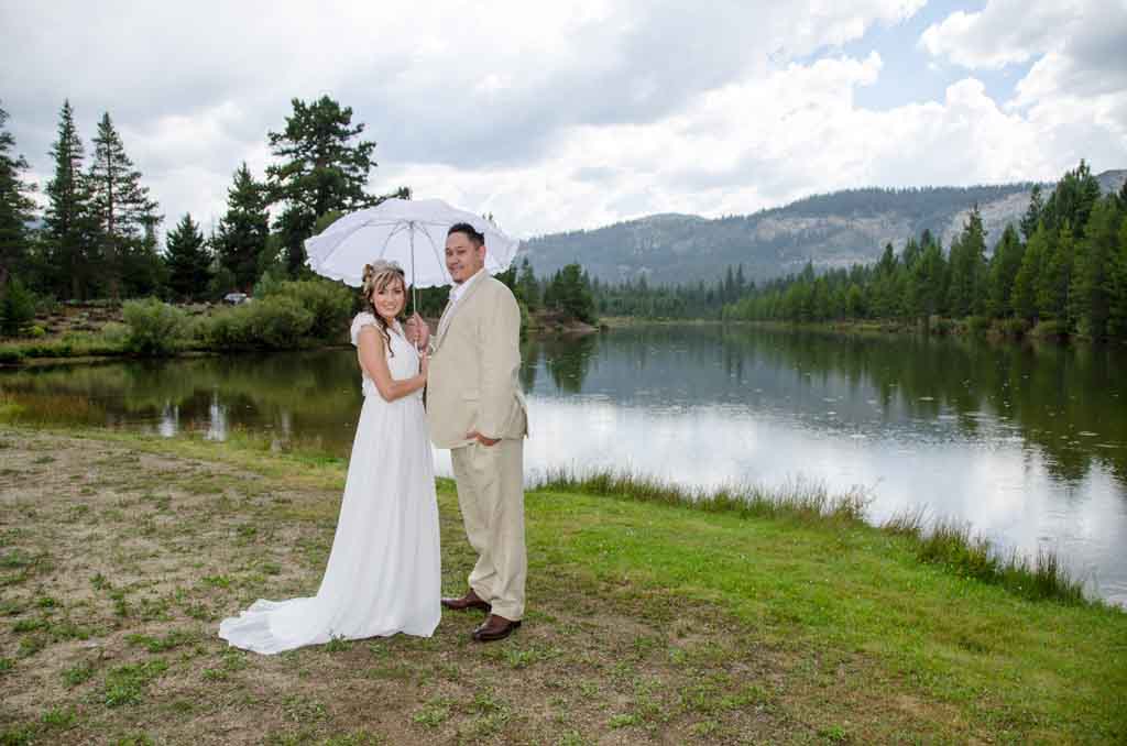 Bride and groom together under umbrella