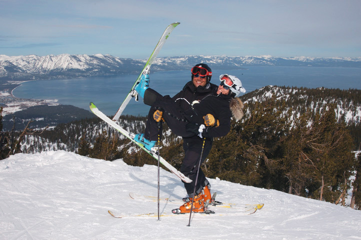 Groom holds bride with her skis in the air