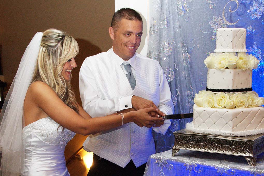 The bride and groom cut the first piece of cake together