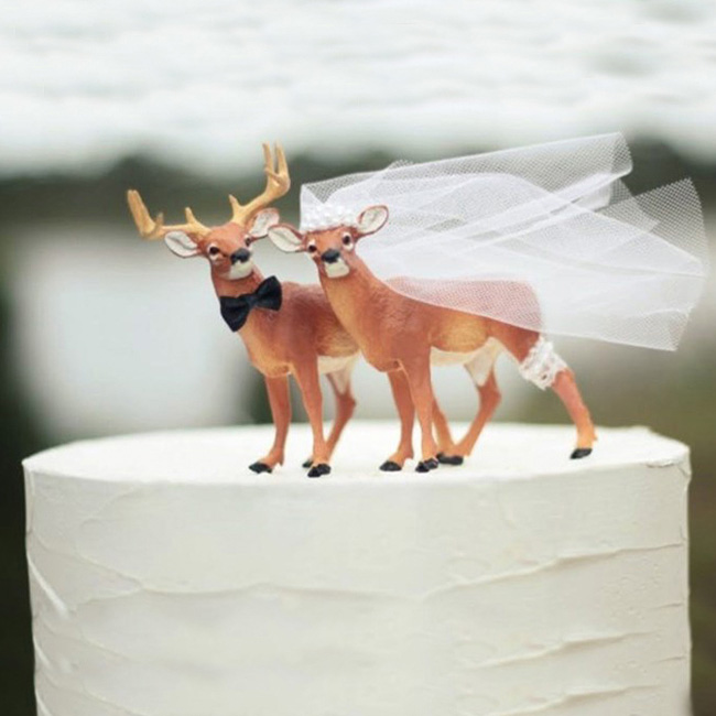 Two deer are on top of cake