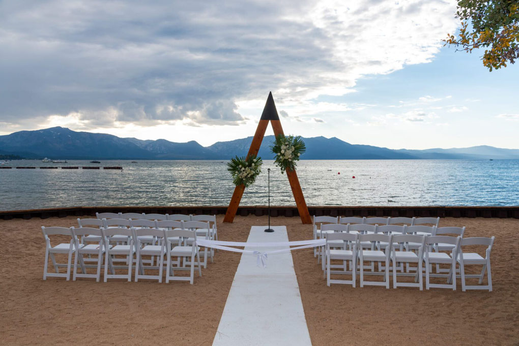 Wedding ceremony site is prepared with chairs and an aisle runner leading up to the arbor