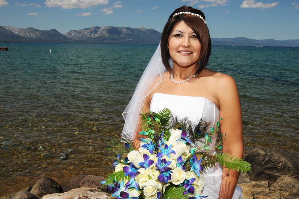 The bride smiles as she holds her beautiful bouquet
