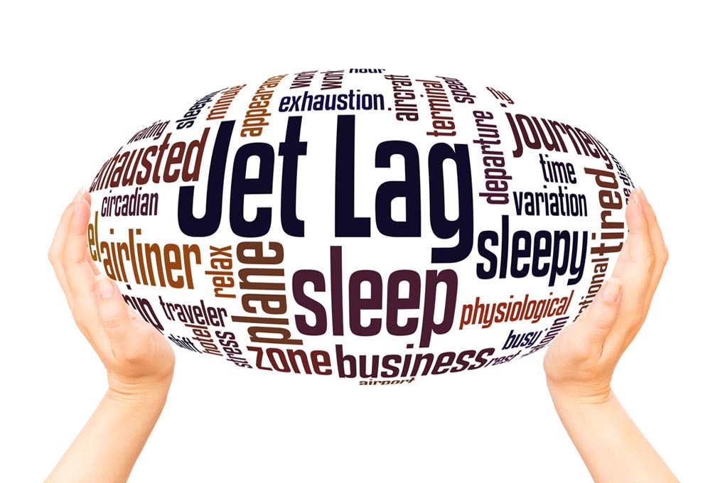 Hands holding up a sphere figure displaying various words such as jet lag and exhaustion
