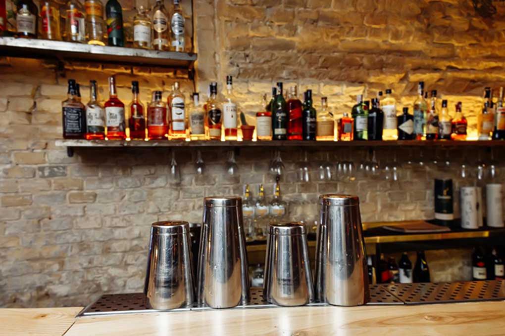 A bar displaying various liquors and tools for making cocktails