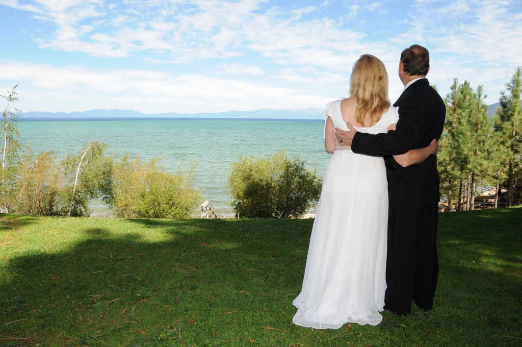 A photo of the bride and groom looking outward towards the lake