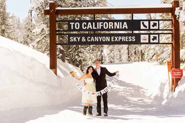 Skiers standing under the Sky and Canyon Express sign on Heavenly Mountain