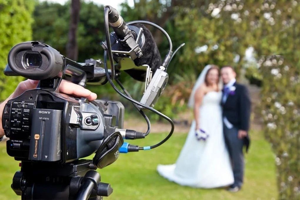 Professional video camera filming the bride and groom