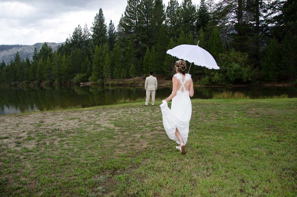 Bride strolls toward her new husband walking under a stylish umbrella.