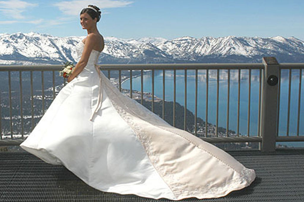 Backside shot of bride's wedding gown as she stands on the observation deck