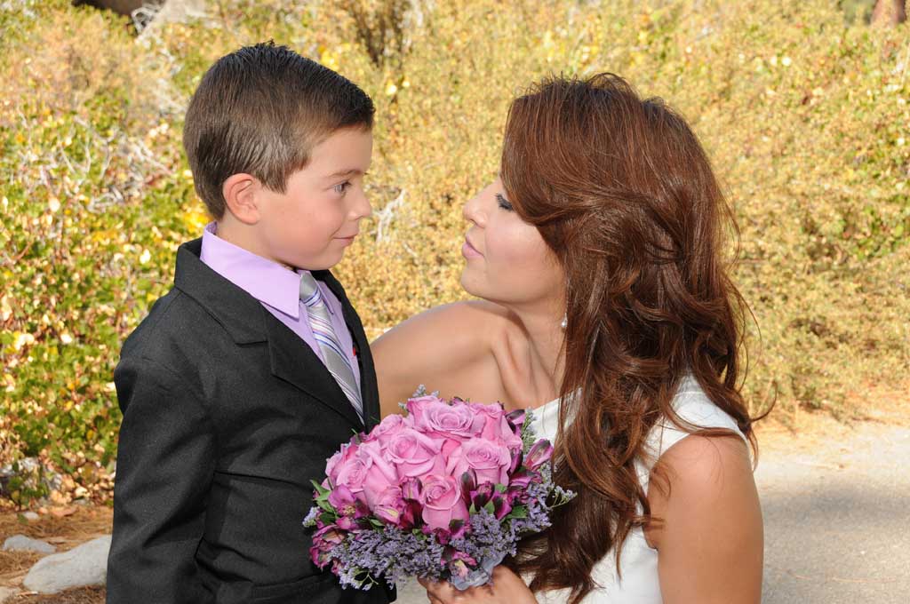 The bride looks affectionately at her son