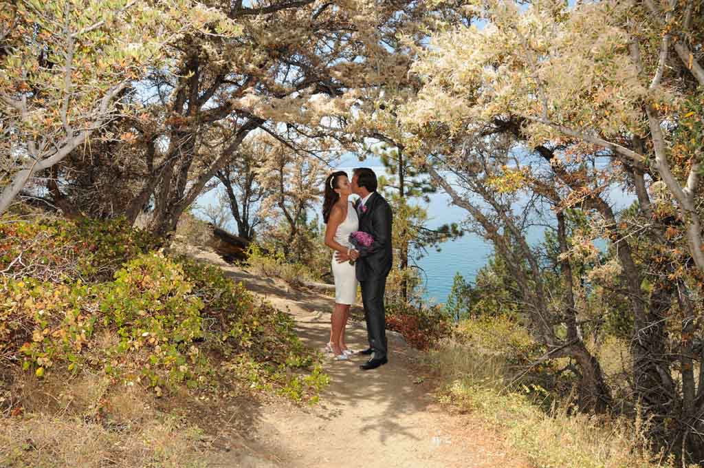 Under cover of beautiful trees, the married pair share a romantic moment