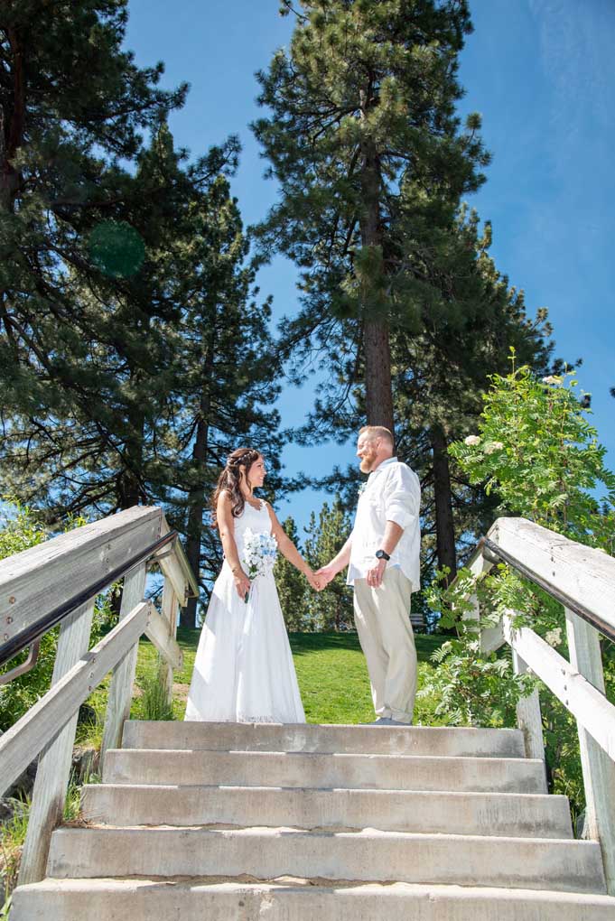 Bride and groom at top of the stairs with trees in the background