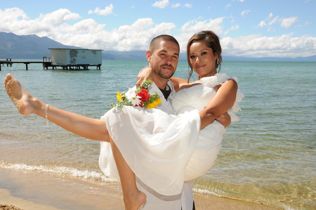 Groom holds his new bride in his arms