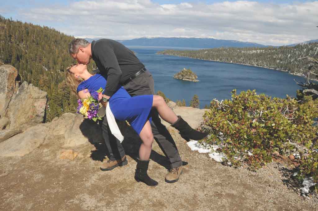 The bridegroom leans his new wife backwards for the first kiss