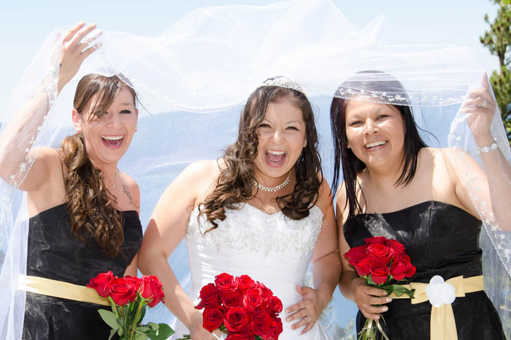 The bridal ladies laughing under the bride's wedding veil