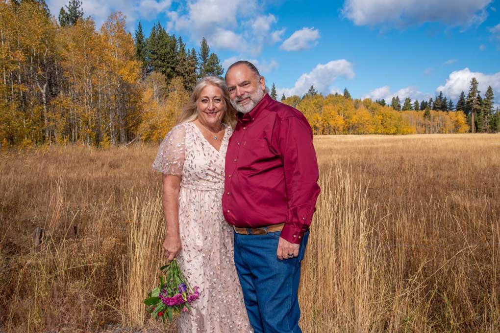 A recently married couple posing in the colorful meadow