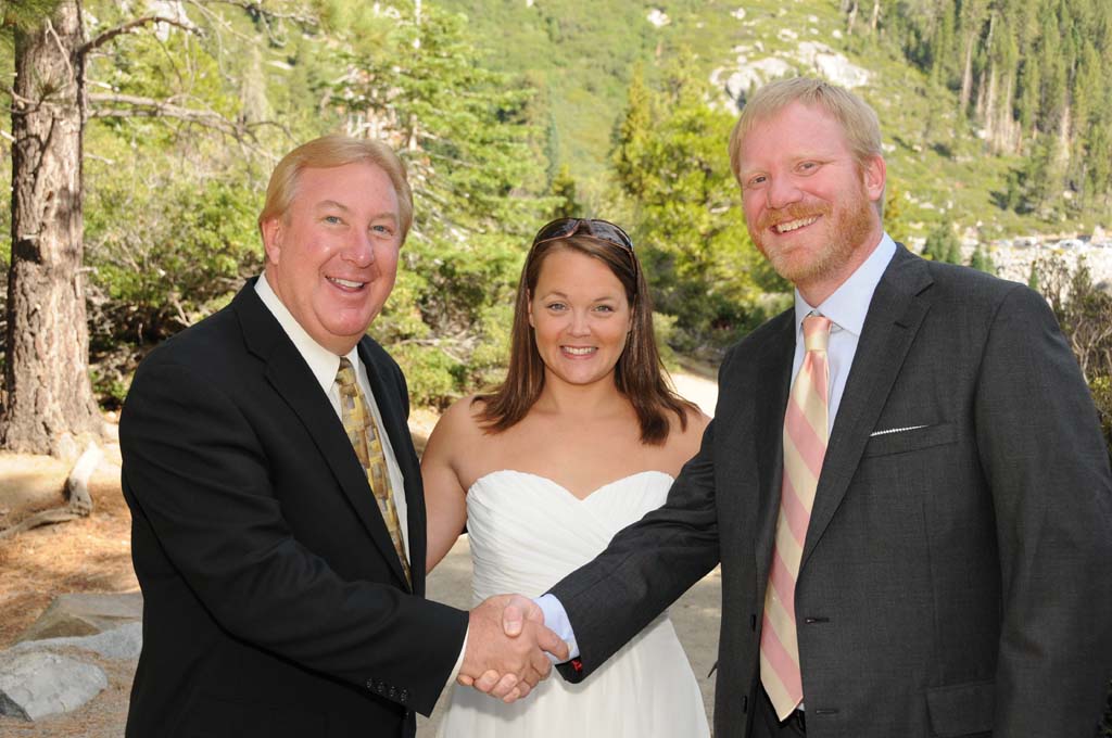 The minister congratulates the groom with a handshake