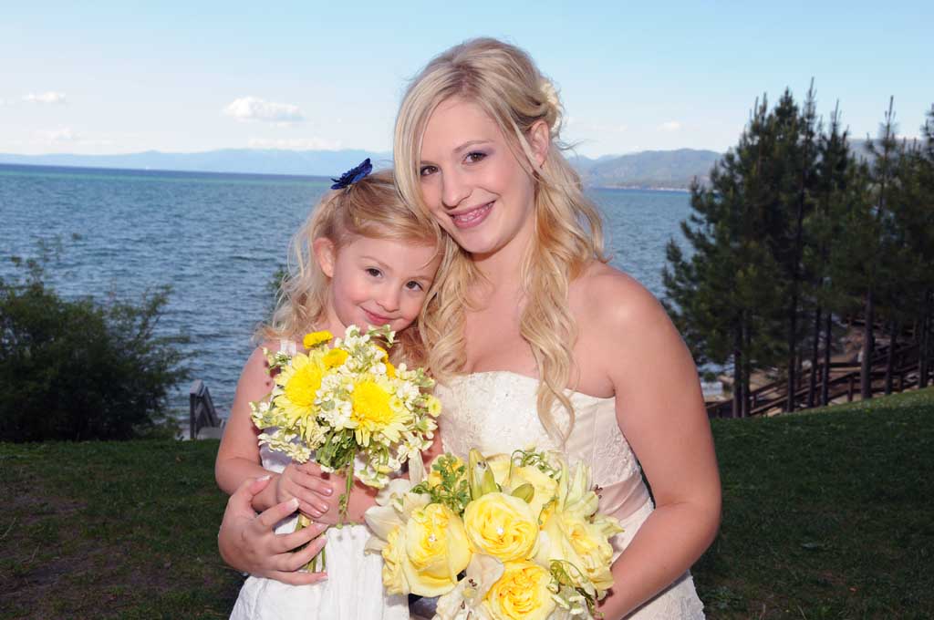 Mom poses with her young daughter while holding their floral bouquets