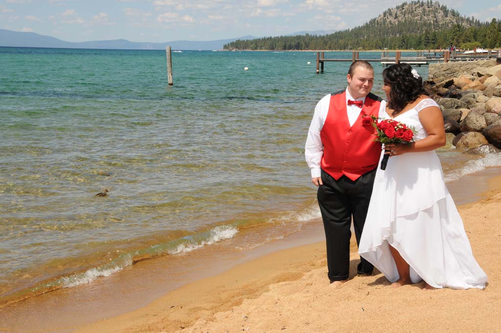 Husband and wife walk along Lake Tahoe formally dressed after their ceremony