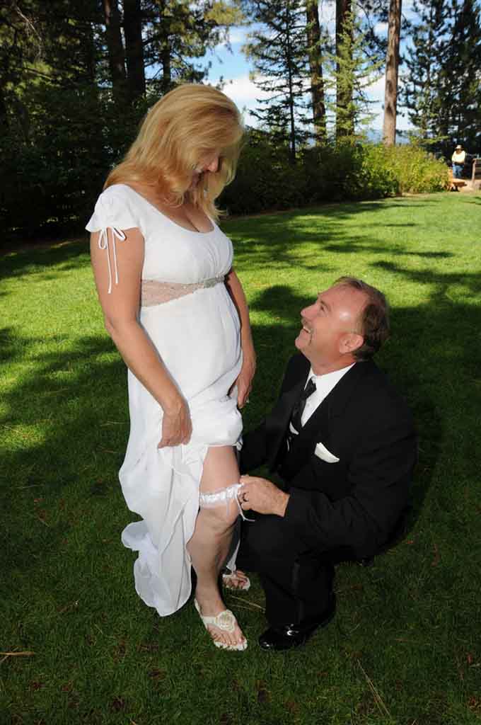 The groom removes the garter from the leg of his new wife