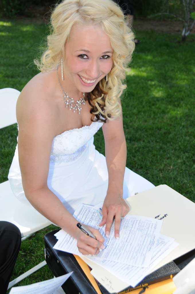 Happy bride signing the marriage license