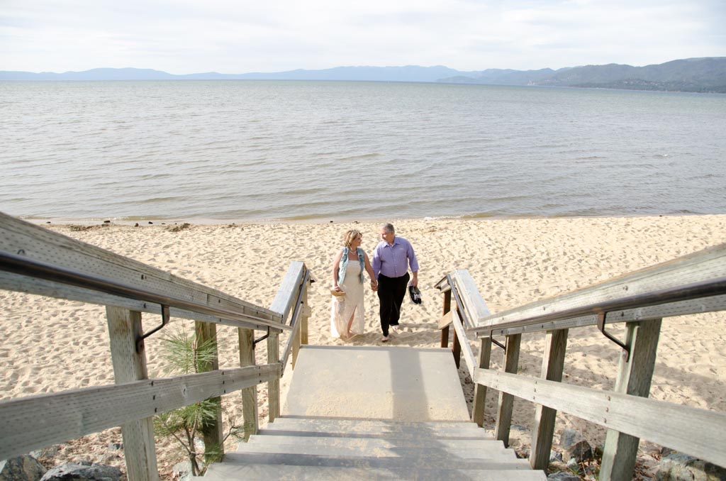 The newly married at the bottom of the staircase that leads to the beach