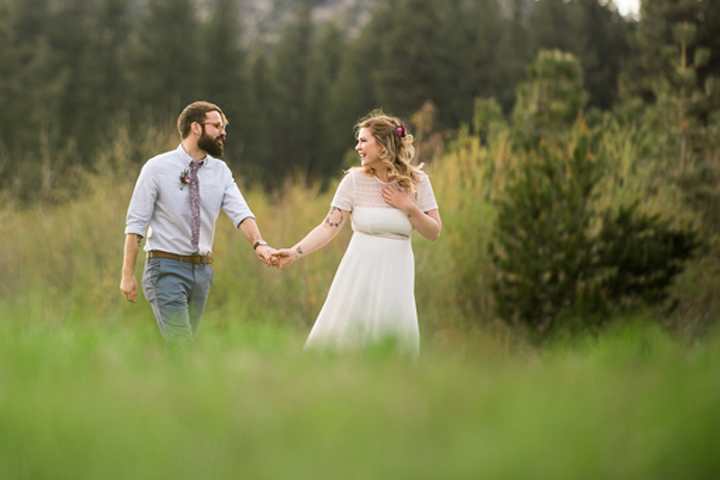 Casually walking in the grassy meadow just after being pronounced husband and wife