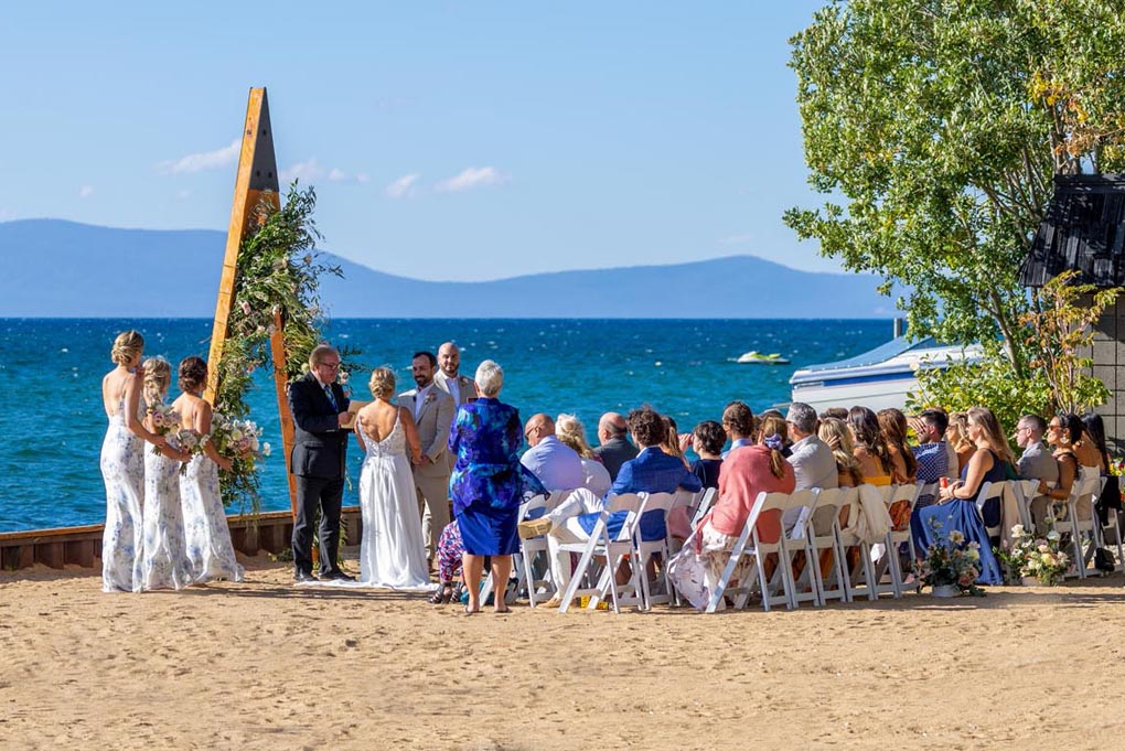 A wedding ceremony in progress near the arch situated on the edge of the lake