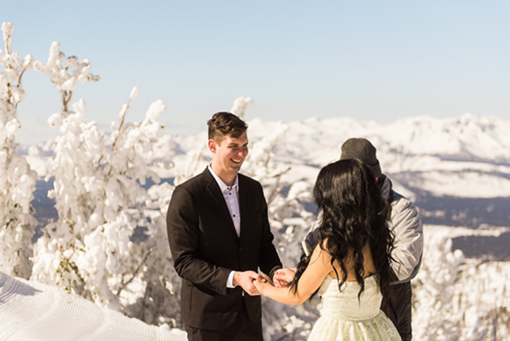 Smiling groom listens to the vow recitation of his bride