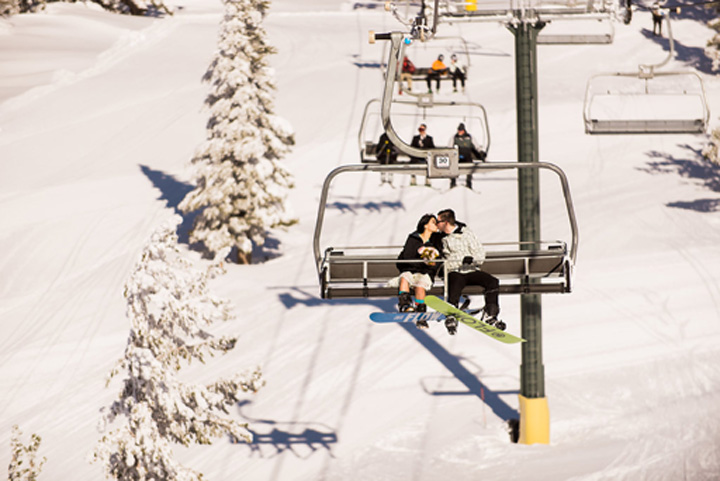 An affectionate kiss between the wedded pair while ascending up the Heavenly Mountain chair lift