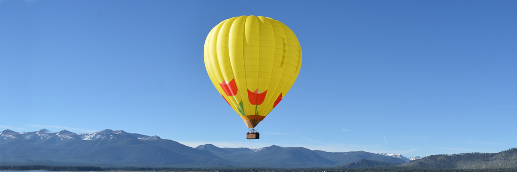 Hot air balloon floating high above Lake Tahoe and the Sierra Nevada mountains