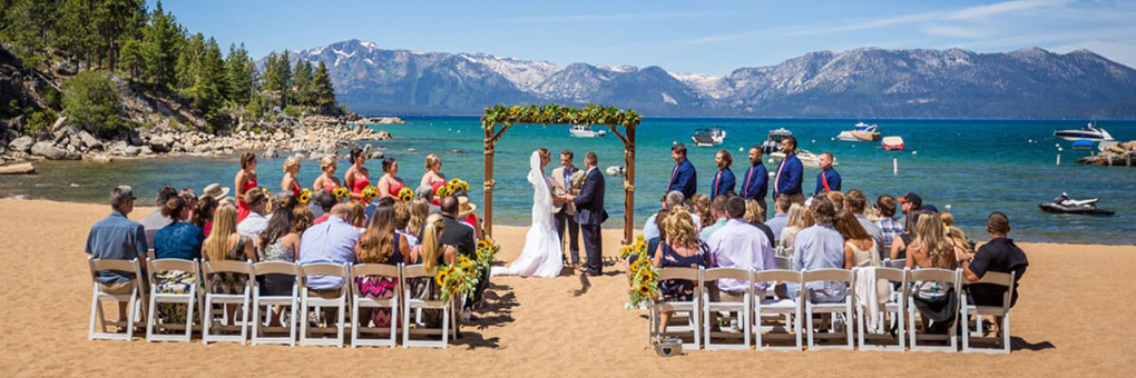 Seated guests watch as the minister conducts the beachside ceremony